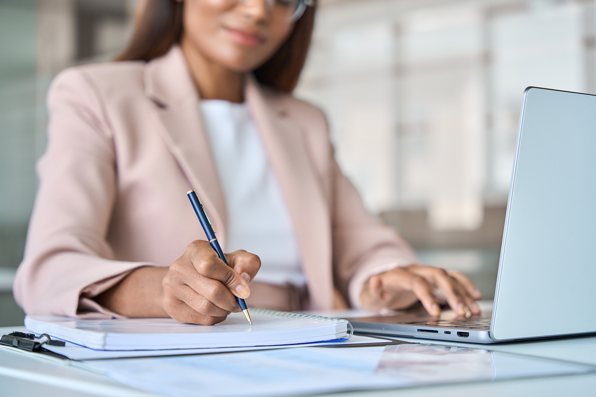 Photo of a person at a desk writing notes.